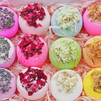 A box filled with vibrant, colorful bath bombs labeled 'Salt Ball' in various shapes and sizes.